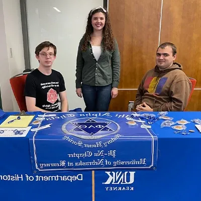 phi alpha theta students sit at a table