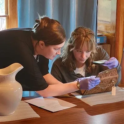 an instructor helps a student examine an artifact